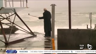 Oceanside trenchcoat guy takes on rain and waves as storm hits North County [upl. by Avehsile]