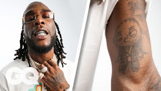 Burna Boy Breaks Down His Tattoos  GQ [upl. by Sonnie]